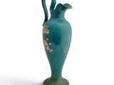 un vase vert orné d'un motif floral