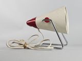 a white and red lamp that is on a metal stand