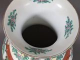 a white vase with a floral design on it