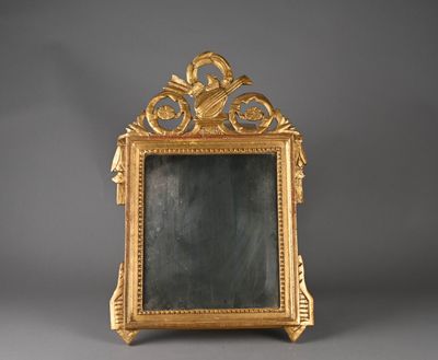 un cadre doré richement décoré, avec un miroir au centre