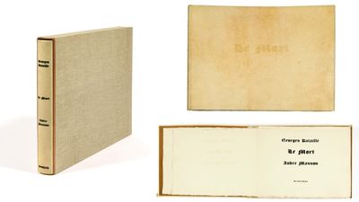 un livre ouvert posé sur une table blanche à côté d'un livre