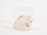 clear rock with a small piece of rock inside of it on a white surface