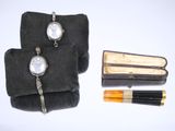 deux montres et un stylo dans un étui posé sur une table