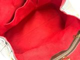 the inside of a red and white purse with a gold zipper