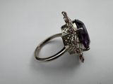 a close up of a ring with a purple stone on it