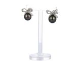 a pair of black pearl and diamond earrings on a clear stand