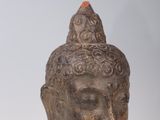statue of a head of a buddha with a red stone on top