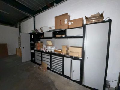 un réfrigérateur dans un garage, avec de nombreux cartons posés dessus