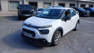une petite voiture blanche garée dans un parking