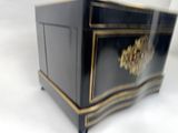 a black cabinet with a gold decoration on it