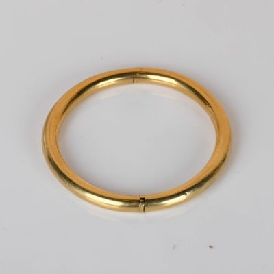 gros plan d'une bague en or sur une surface blanche