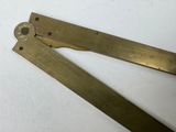 a pair of brass rulers laying on a white surface
