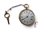 une montre à gousset en or à laquelle est attachée une clé
