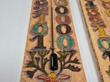 two wooden signs with different designs on them on a table