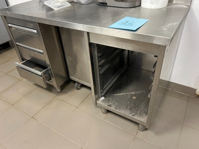 un plan de travail en acier inoxydable dans une cuisine, sur lequel est posée une casserole