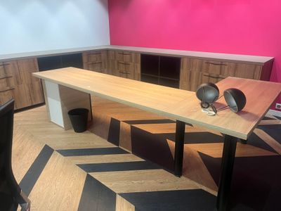 une table sur laquelle se trouve un vase, dans une pièce rose
