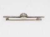 a close up of a silver tie bar on a white surface