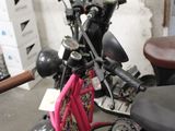 a pink scooter that is parked in a garage