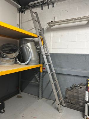 a ladder that is next to a shelf with pots and pans on it