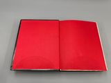 un livre rouge ouvert posé sur une table