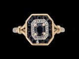 un gros plan d'une bague en or sertie d'un diamant noir et blanc