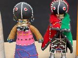 two dolls that are standing next to each other on a table