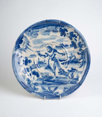 assiette bleue et blanche représentant un homme dans un bateau sur l'eau