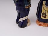 two figurines of a man and a woman standing next to each other