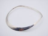 a close up of a silver bracelet on a white surface