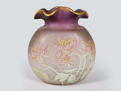 a purple vase with flowers on it sitting on a white surface