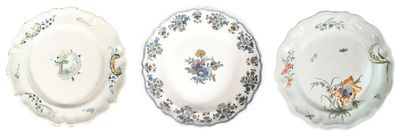 trois assiettes ornées de motifs floraux sont alignées sur une surface blanche