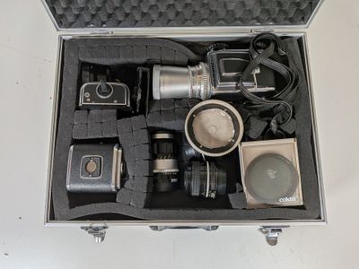 a silver case with a camera and other items in it