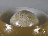a bowl with a ball inside of it on a table