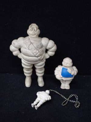 une figurine représentant un homme avec une chaîne autour du cou et une petite figurine représentant un homme avec une chaîne autour du cou