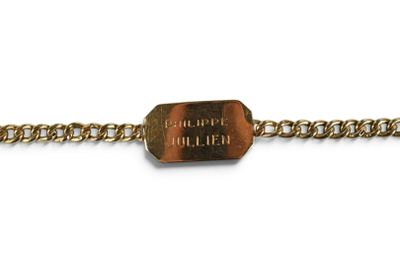 Gros plan sur un bracelet en chaîne en or portant une étiquette