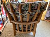 a wooden chair with a floral cushion on it in a room