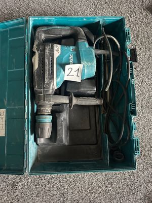 une boîte bleue contenant une perceuse et un cordon