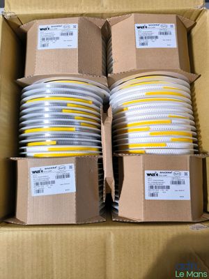 plusieurs boîtes contenant des disques en plastique blancs et jaunes, le tout dans une boîte en carton