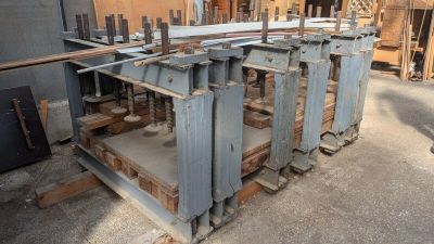 de nombreuses pièces métalliques empilées sur des palettes dans un entrepôt