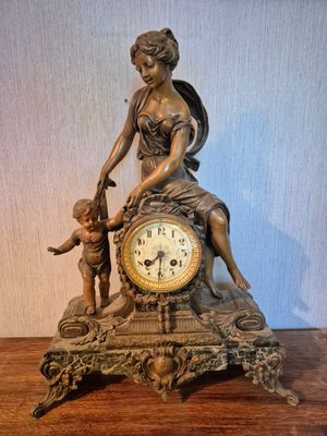 une statue de femme assise au sommet d'une horloge