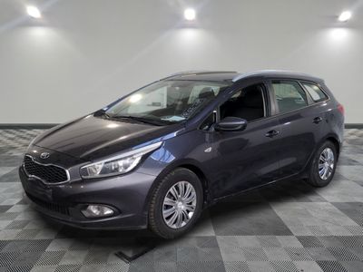 a gray car is parked on a checkered floor in a garage