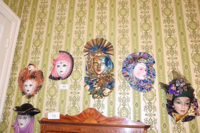 de nombreux masques accrochés au mur au-dessus d'une commode