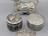 un ensemble de quatre objets en argent, comprenant notamment un lion et une boîte