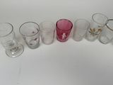 many glasses lined up on a white surface