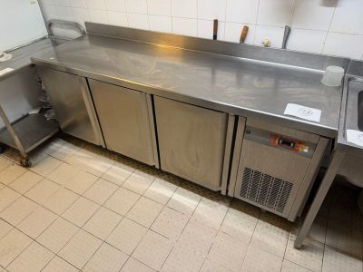 a large stainless steel kitchen with a sink and a refrigerator