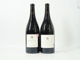 deux bouteilles de vin posées l'une à côté de l'autre sur une surface blanche