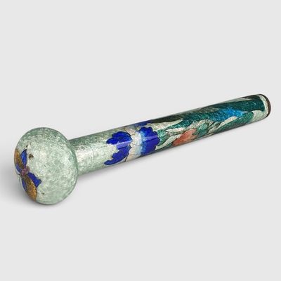 une pipe en verre posée sur une surface blanche