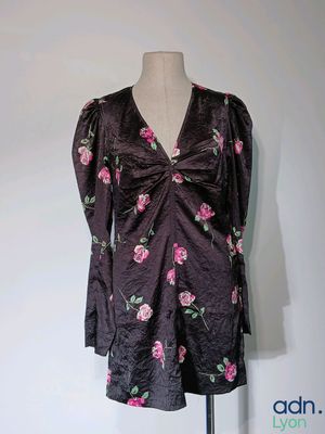 une robe posée sur un mannequin, ornée d'un motif de roses