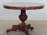 une photo d'une table au plateau en marbre posée sur un piètement en bois