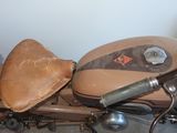 a brown motorcycle with a leather seat and seat pad on it